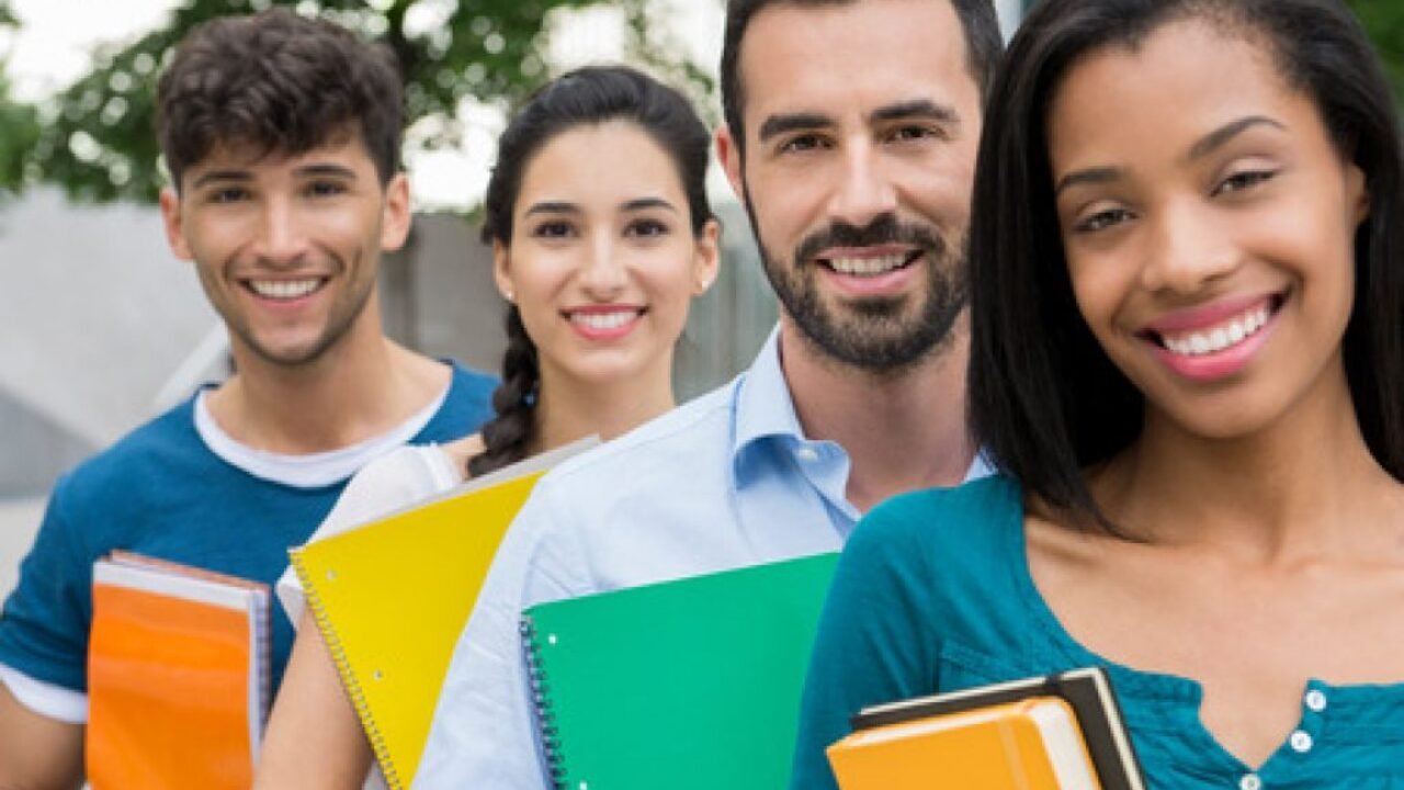 45334790-primer-disparo-de-los-estudiantes-universitarios-de-pie-en-una-fila-con-los-libros-grupo-feliz-y-son-1024x680