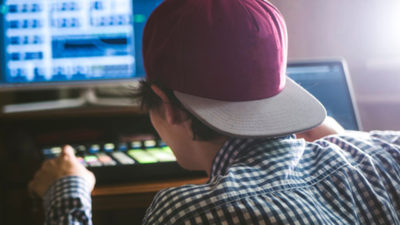 young smiling happy man in the sound recording studio working on the new track