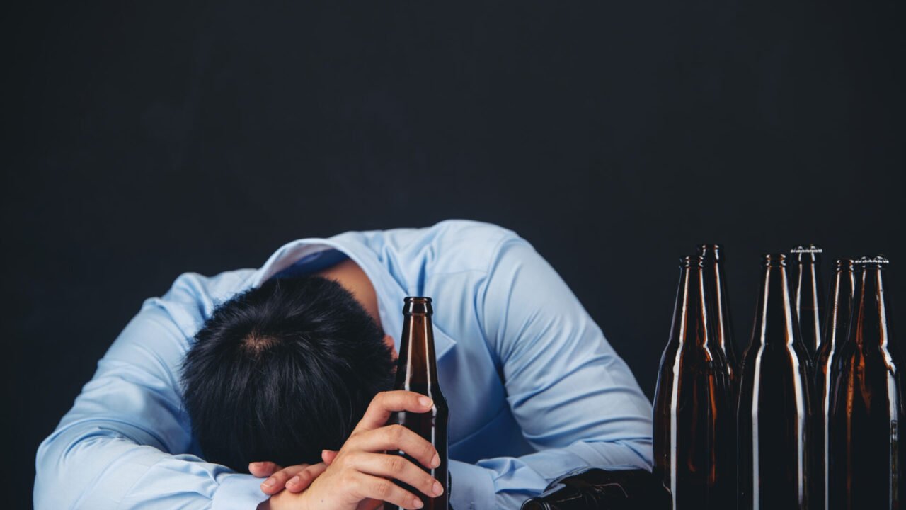 Cropped close up of a man drinking beer at the home