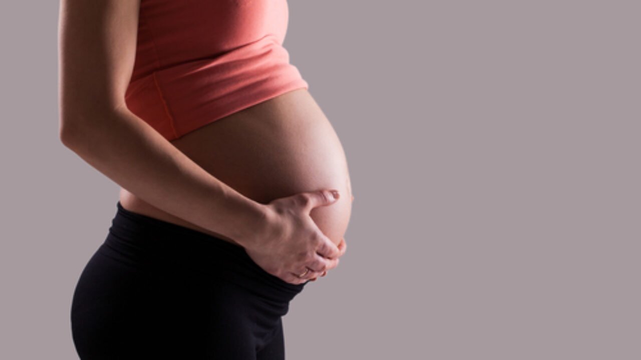 Beautiful pregnant belly on a grey background