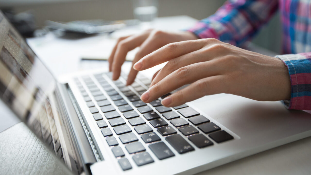 Cropped view of person hands typing on laptop computer